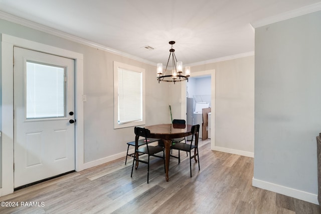 dining room featuring a notable chandelier, ornamental molding, and light wood-type flooring