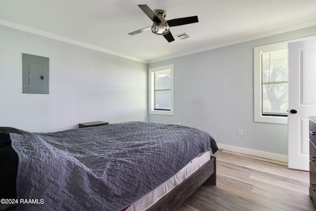 bedroom featuring ornamental molding, ceiling fan, electric panel, and light wood-type flooring