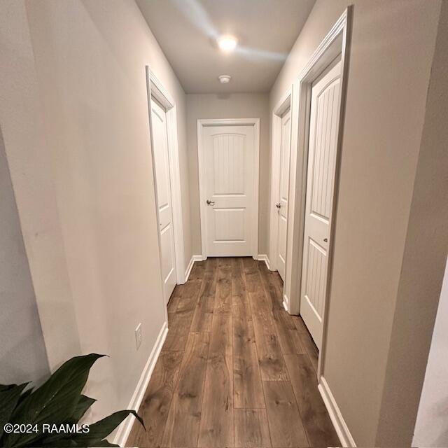 corridor with dark hardwood / wood-style floors