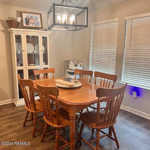 dining space with dark wood-type flooring and a chandelier