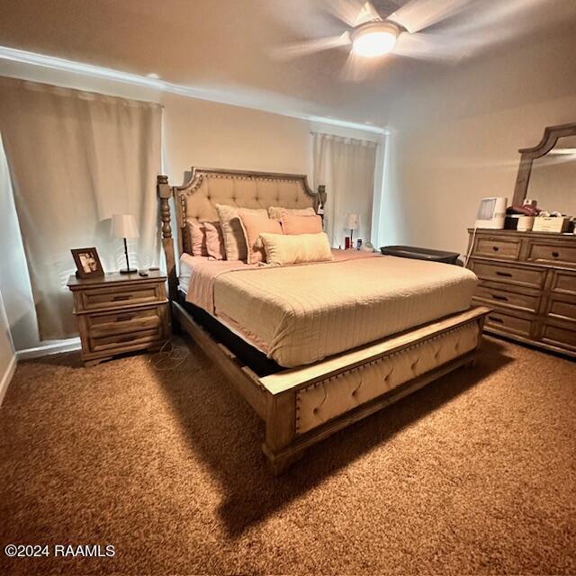 bedroom with ceiling fan and dark colored carpet