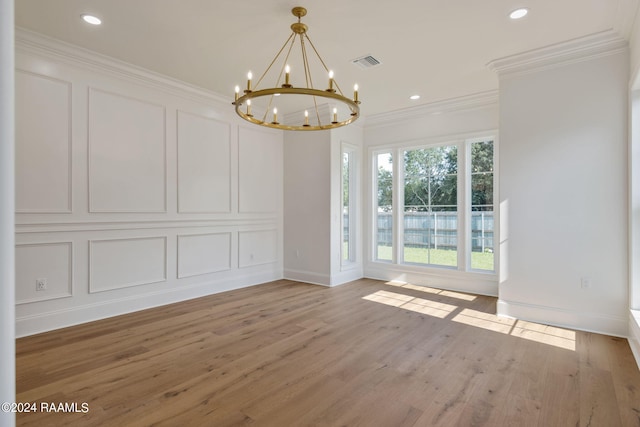 interior space featuring light wood-style flooring, visible vents, a decorative wall, and crown molding