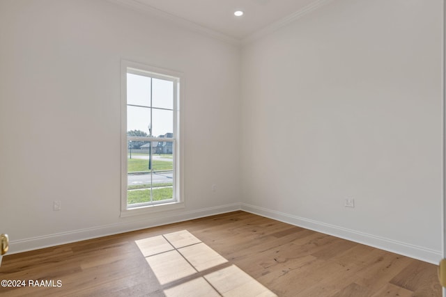 empty room with ornamental molding and light hardwood / wood-style flooring