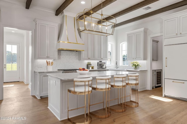 303 Ivy Cottage Dr, Youngsville, LA 70592 - kitchen featuring paneled refrigerator, beamed ceiling, a center island, tasteful backsplash, and custom exhaust hood
