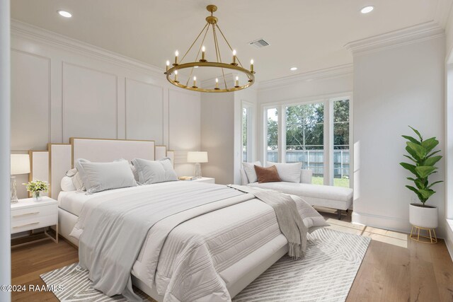 bedroom with a notable chandelier, light hardwood / wood-style floors, and crown molding