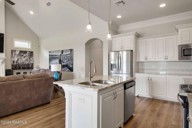 kitchen featuring appliances with stainless steel finishes, white cabinets, sink, backsplash, and hardwood / wood-style flooring