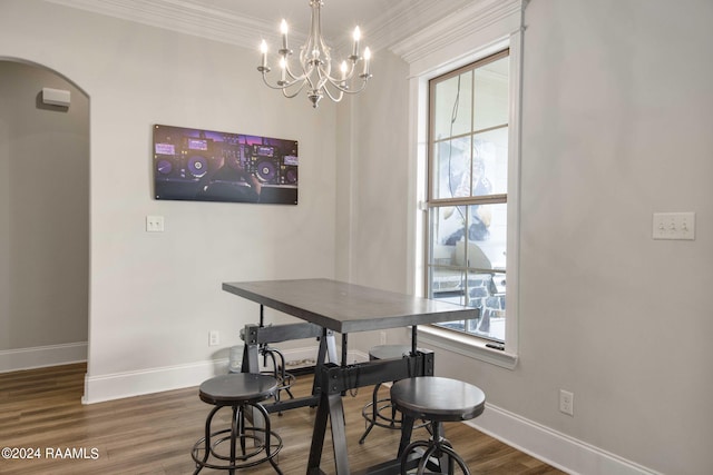 dining area with dark wood-type flooring, ornamental molding, a chandelier, and a wealth of natural light