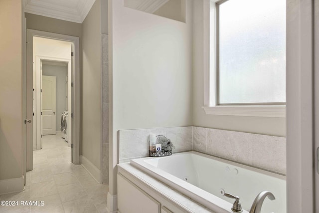 bathroom featuring washer / clothes dryer, ornamental molding, a bathtub, and tile patterned floors