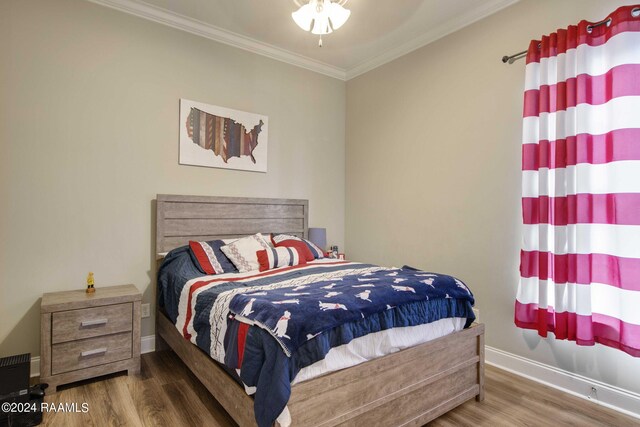 bedroom featuring wood-type flooring, crown molding, and ceiling fan