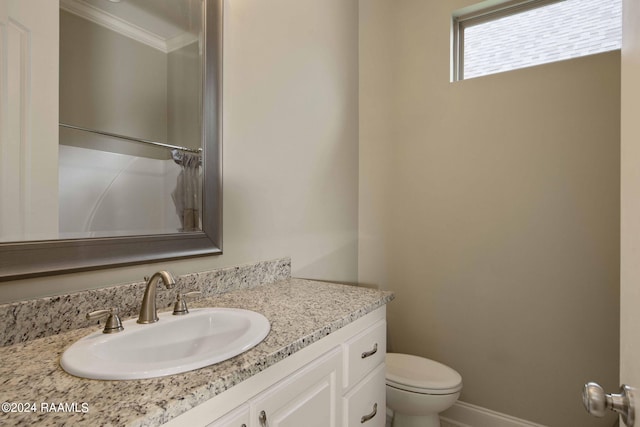 bathroom with crown molding, toilet, and vanity