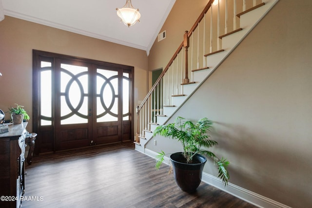 foyer entrance featuring dark wood-type flooring, ornamental molding, french doors, and a high ceiling