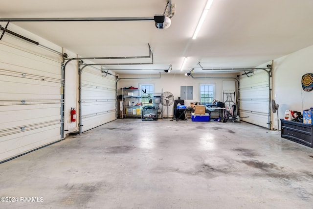 garage with a garage door opener and electric panel