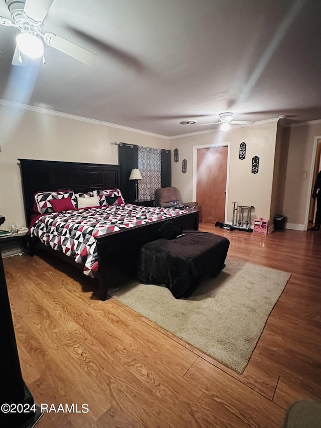 bedroom with crown molding, wood finished floors, and a ceiling fan