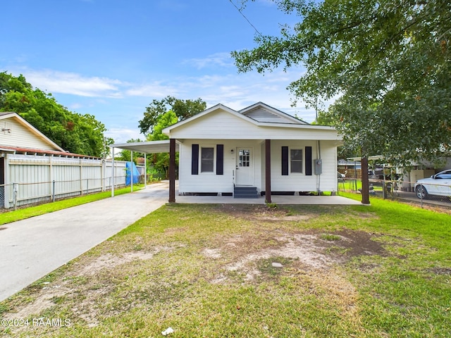 bungalow-style home with a porch, a front lawn, and a carport