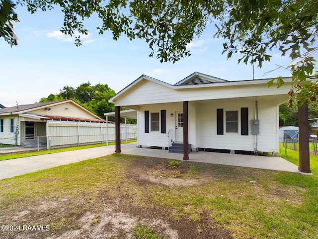 view of front of house with entry steps, a front lawn, fence, and driveway