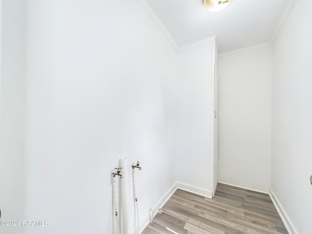 clothes washing area with light wood-type flooring, crown molding, baseboards, hookup for a washing machine, and laundry area