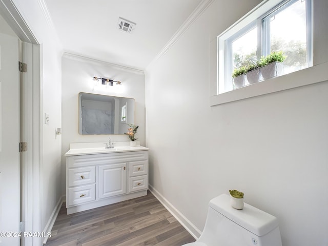 bathroom with vanity, ornamental molding, hardwood / wood-style flooring, and toilet