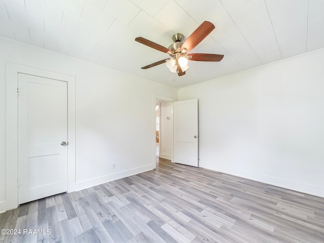 unfurnished room with light wood finished floors, a ceiling fan, and baseboards