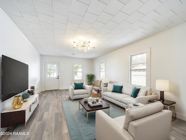 living room featuring hardwood / wood-style flooring, a chandelier, and ornamental molding