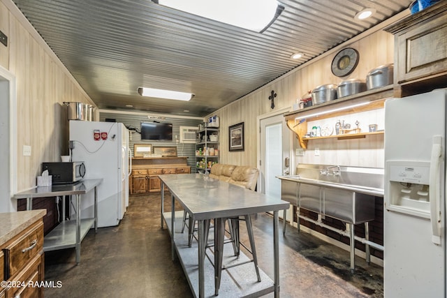 kitchen with white refrigerator, white refrigerator with ice dispenser, and wood walls