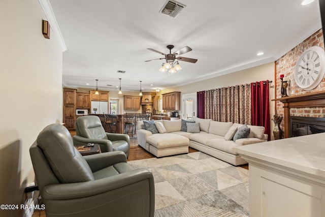 living room featuring ornamental molding, ceiling fan, and a fireplace