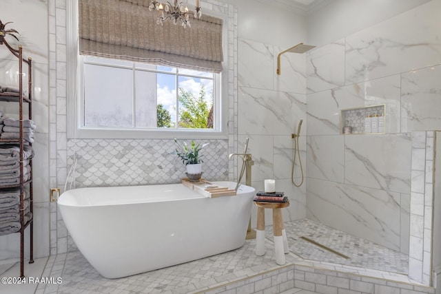 bathroom featuring plus walk in shower, an inviting chandelier, and tile walls