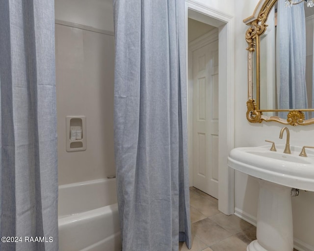 bathroom with tile patterned flooring, shower / bath combination with curtain, and sink