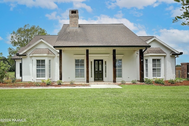 rear view of property featuring a yard and covered porch