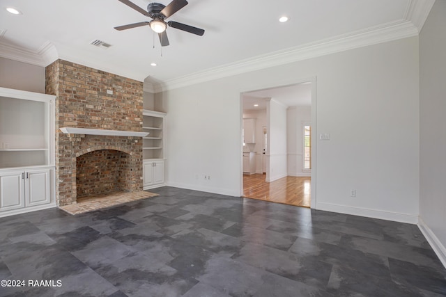 unfurnished living room featuring built in shelves, a brick fireplace, ceiling fan, and crown molding