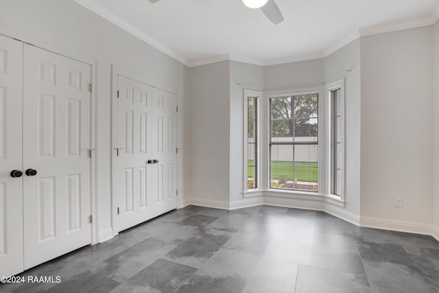 unfurnished bedroom with two closets, ceiling fan, and ornamental molding