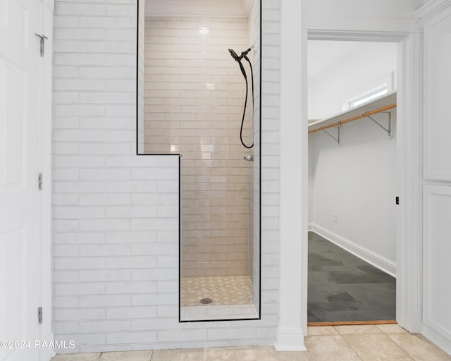 bathroom with tile patterned flooring and tiled shower