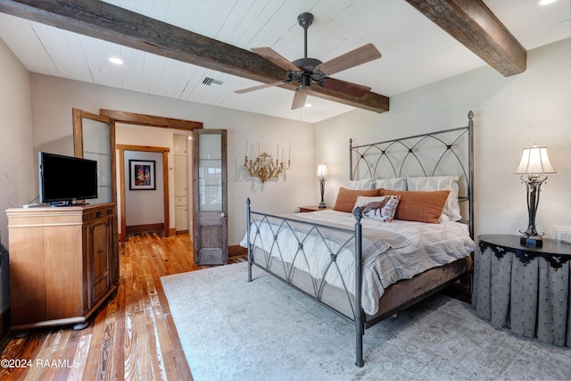 bedroom featuring visible vents, beamed ceiling, baseboards, ceiling fan, and light wood-style floors