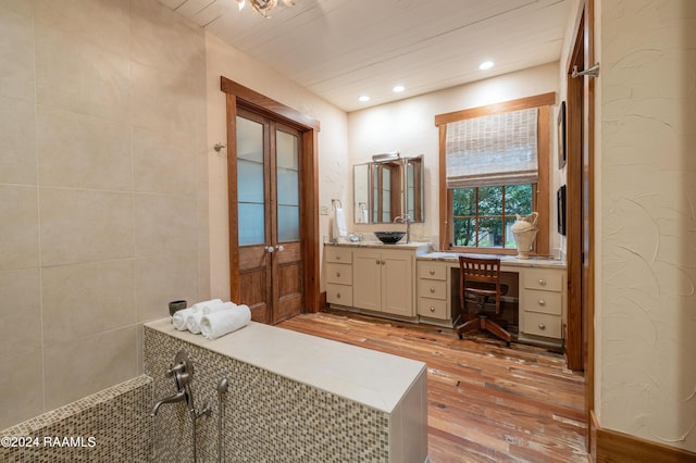 bathroom with a textured wall, vanity, recessed lighting, and hardwood / wood-style floors
