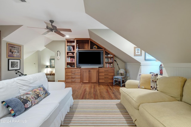 living area with a ceiling fan, visible vents, lofted ceiling, and wood finished floors