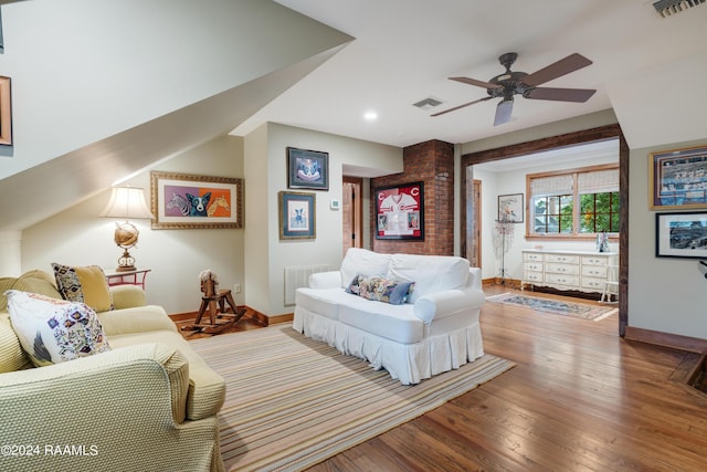 living room with baseboards, visible vents, a ceiling fan, and hardwood / wood-style flooring