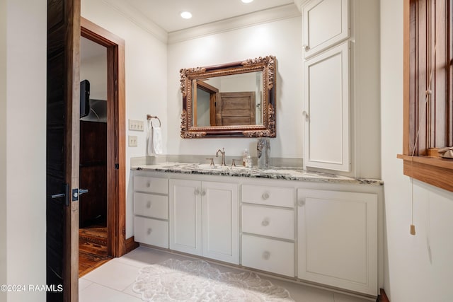 bathroom with crown molding, tile patterned flooring, and vanity
