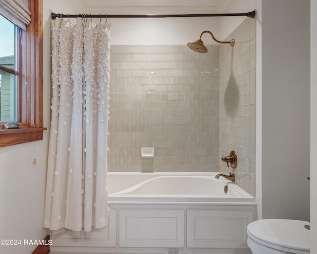 bathroom featuring toilet and shower / bathtub combination with curtain