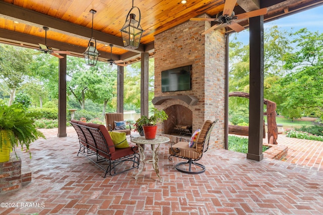view of patio featuring an outdoor brick fireplace and ceiling fan