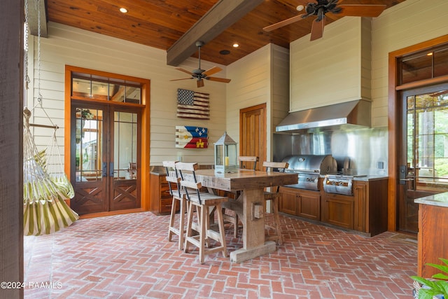 kitchen with a ceiling fan, brick floor, french doors, brown cabinetry, and wood ceiling