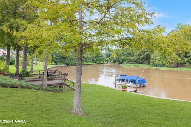 dock area with a water view and a yard