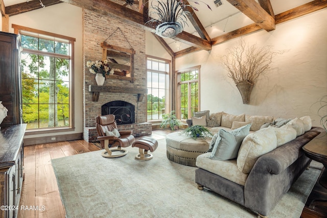 living room with high vaulted ceiling, beam ceiling, hardwood / wood-style flooring, a fireplace, and visible vents