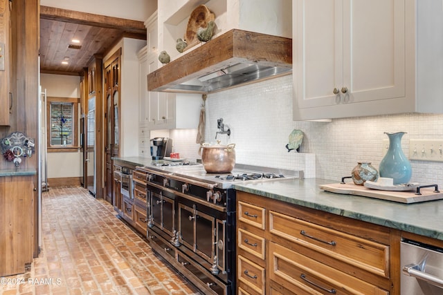 kitchen with custom range hood, decorative backsplash, wood ceiling, brick floor, and range with two ovens