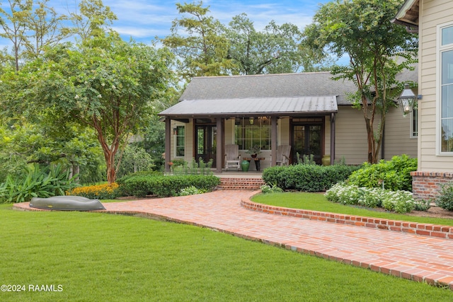 rear view of property featuring a porch and a yard