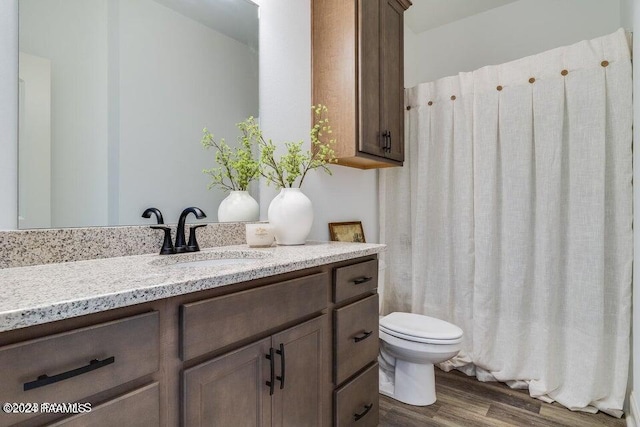 bathroom with hardwood / wood-style floors, vanity, and toilet