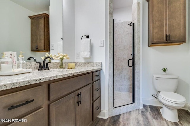 bathroom featuring vanity, a shower with shower door, toilet, and hardwood / wood-style flooring