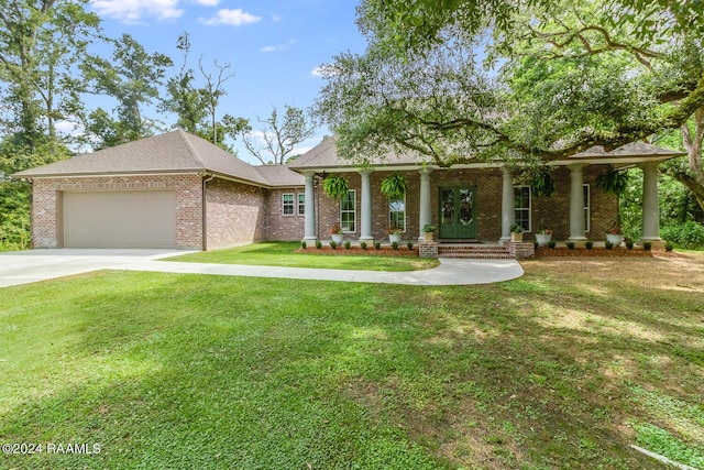 view of front of home featuring covered porch, a front lawn, and a garage