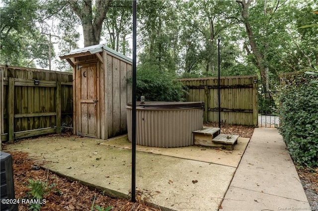 319 Goodwin St, Welsh, LA 70591 - fenced backyard with a hot tub, a shed, and a patio area