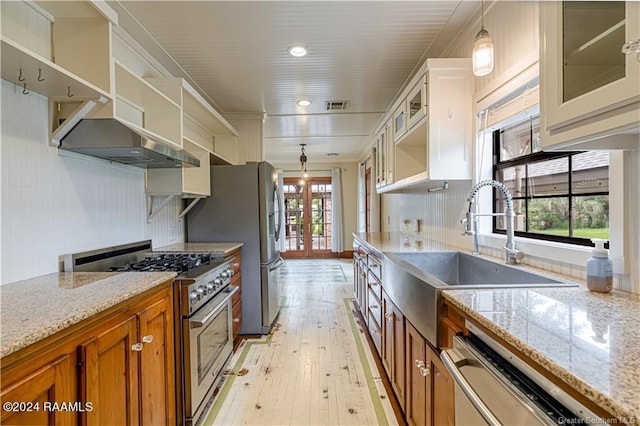 319 Goodwin St, Welsh, LA 70591 - kitchen featuring appliances with stainless steel finishes, open shelves, brown cabinets, light wood-style flooring, and ventilation hood
