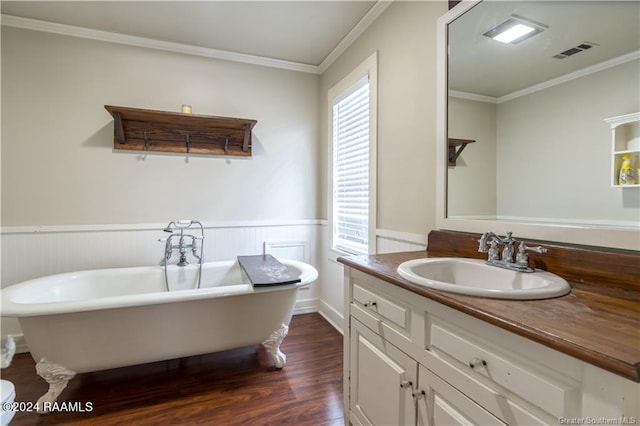 319 Goodwin St, Welsh, LA 70591 - bathroom featuring vanity, wood finished floors, plenty of natural light, wainscoting, and a freestanding tub