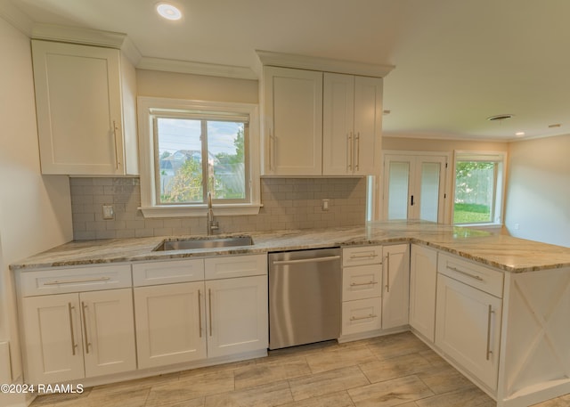 kitchen featuring stainless steel dishwasher, kitchen peninsula, sink, and white cabinets